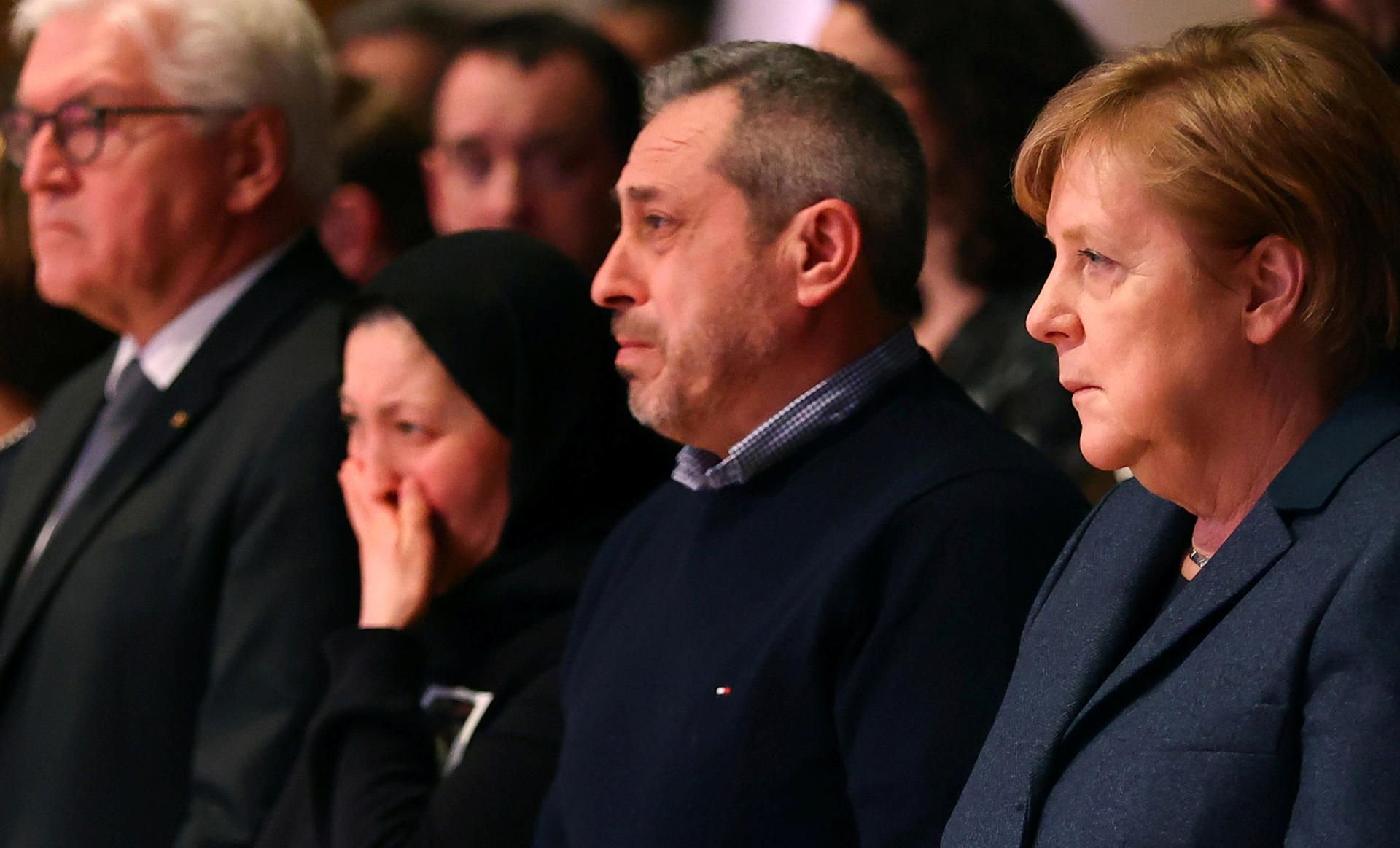 Bundeskanzlerin Angela Merkel und Bundespräsident Frank-Walter Steinmeier sitzen neben Angehörigen eines Opfers des rechtsradikalen Anschlags von Hanau.