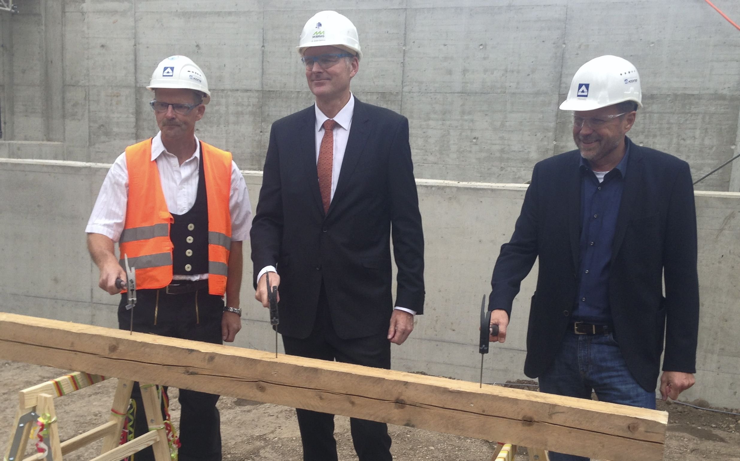 Hochtief-Polier Gerd Fichtmüller, Mibragchef Armin Eichholz und Hochtief-Niederlassungsleiter Lutz Reimann (v. l.) bei den traditionellen Hammerschlägen für das Richtfest an der Grubenwasserreinigungsanlage der Mibrag in Profen.