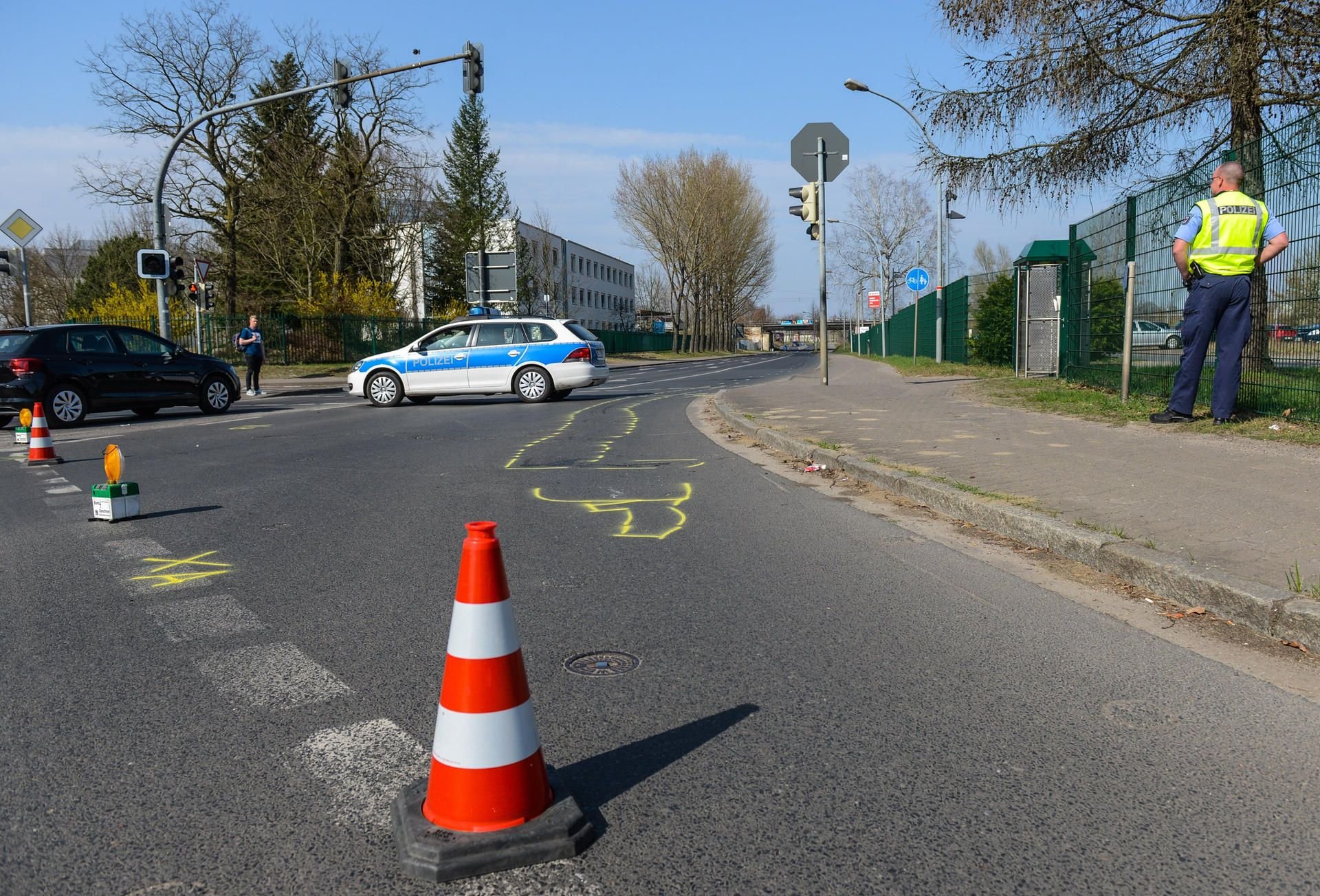 Oranienburg: Ein Polizeifahrzeug steht hinter einer Absperrung am Unfallort. Eine 59-jährige Radfahrerin ist von einem abbiegenden Lastwagen erfasst und getötet worden.