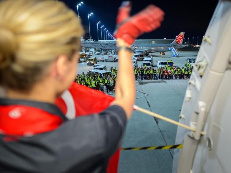 Eine Flugbegleiterin der Fluggesellschaft Air Berlin winkt am auf dem Flughafen in München weiteren Mitarbeitern der Airline vor dem letzten Flug zur Verabschiedung. Foto: Gregor Fischer/dpa