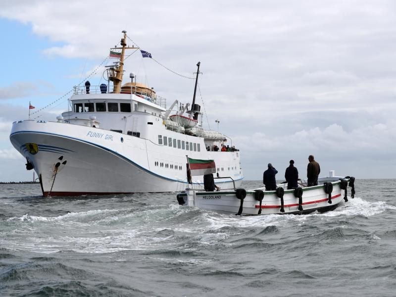 Ein Börteboot ist auf dem Weg zu dem Ausflugsschiff Funny Girl. Foto: Christian Charisius/Archivbild