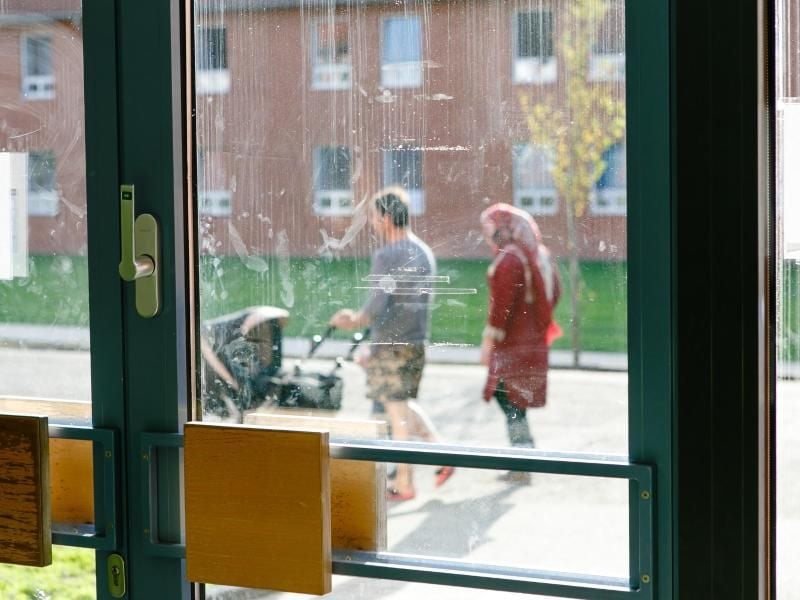 Eltern schieben beim Spaziergang einen Kinderwagen in einer Flüchtlingsunterkunft. Foto: Frank Molter/Archiv