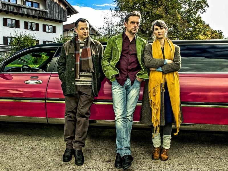 Gruppenfoto mit Geltinger Schwindler-Trio vor farbiger Strechlimousine: Gerhard Wittmann (Karl Kainz), Sebastian Bezzel (Hubertus Hochstetter) und Kathrin von Steinburg (Iris Schranner). Foto: WDR