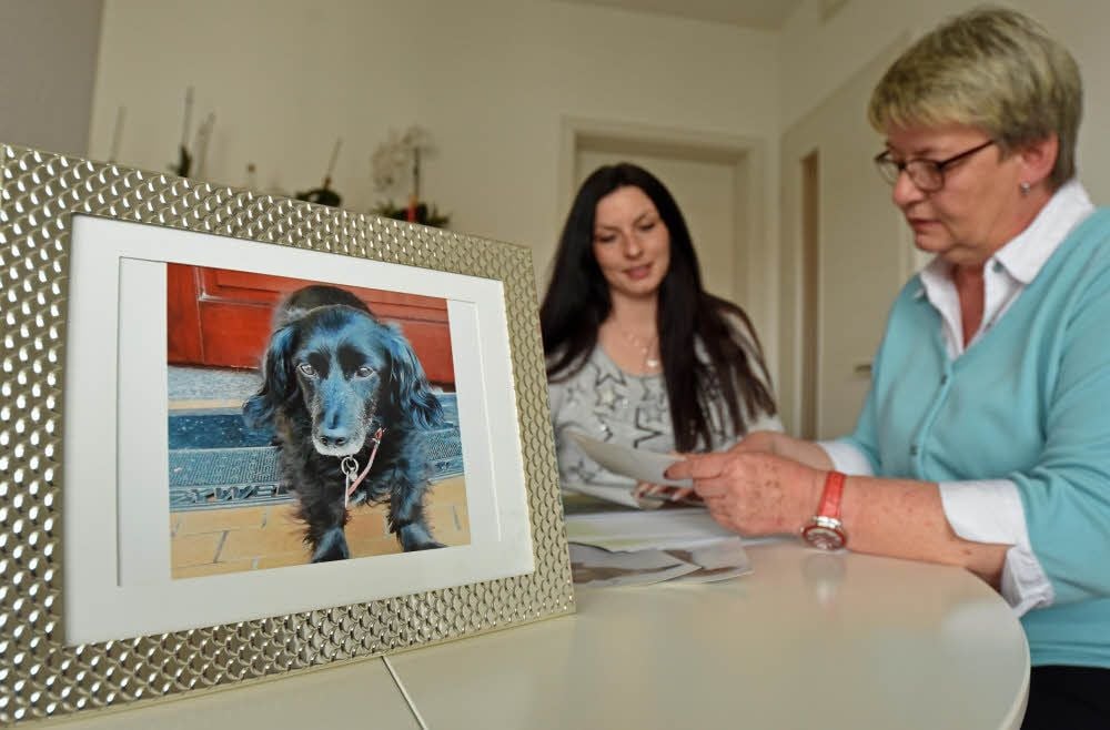 Aline und Mutter Regina Bruschke schauen sich alte Bilder ihres Dackels an. Er wurde von einem Schäferhund totgebissen.