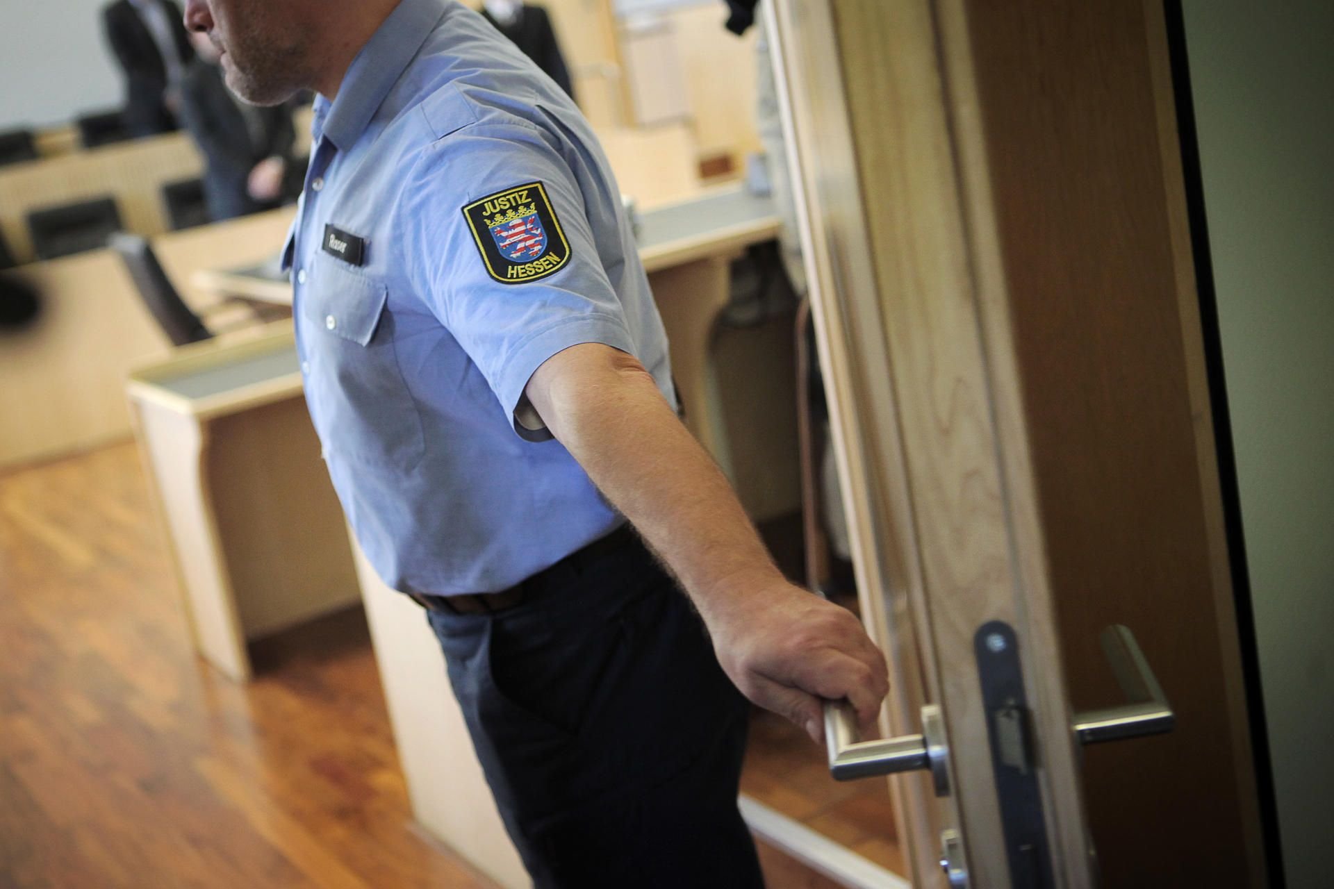 Ein Justizbeamter schließt im Landgericht in Limburg (Hessen) die Tür zum Verhandlungsraum.