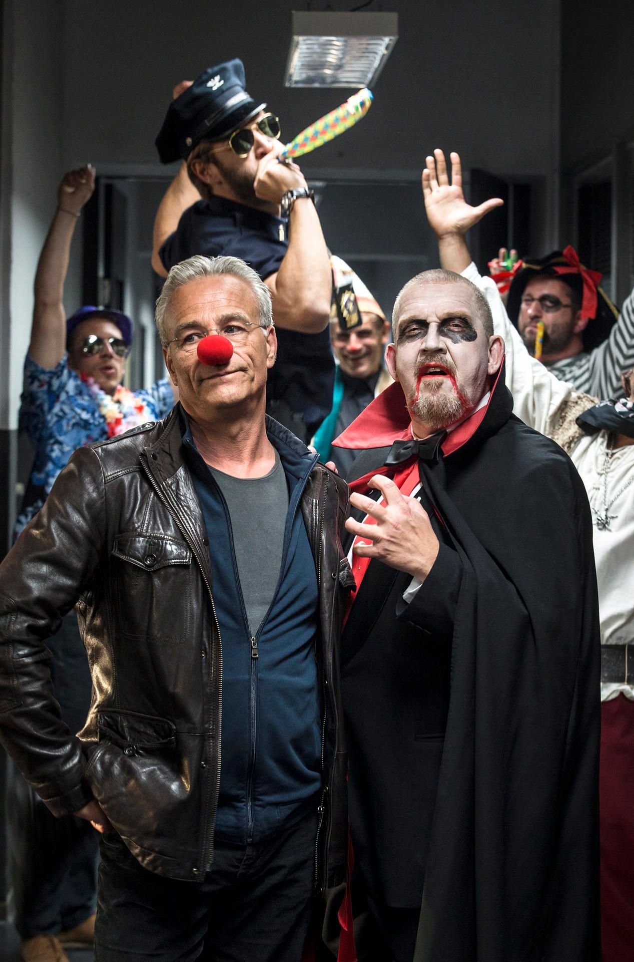 Die verkleideten Kollegen nötigen den Karnevalsmuffel Ballauf zum Schluss, zu einer Karnevalsparty mitzukommen.