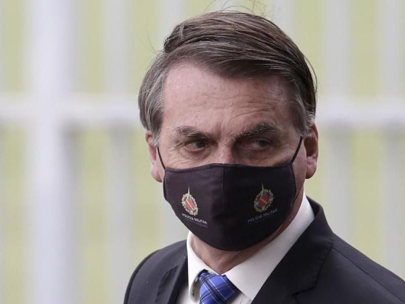 Jair Bolsonaro, Präsident von Brasilien, trägt beim Verlassen seines Amtssitzes, dem Alvorada-Palast, einen Mundschutz. Foto: Eraldo Peres/AP/dpa