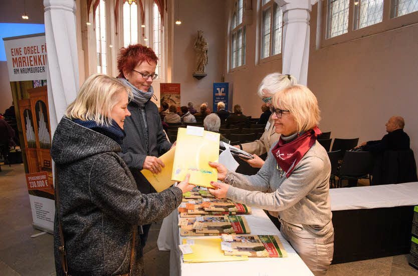 Die ehrenamtlichen Helferinnen Ute Schröter und Monika Elstner (r) übergeben den Teilnehmerinnen der Kulturakademie Antje Köhler-Seifert (l.) und Katrin Kießling (z.v.l.) die Seminarunterlagen.