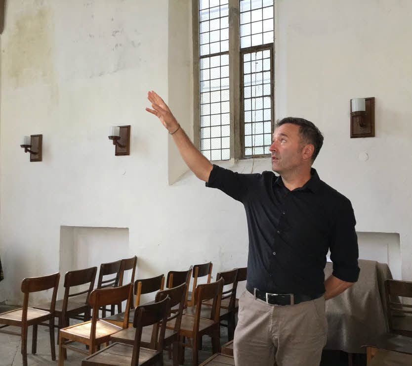 Jens Schumann vom Kreiskirchenamt zeigt Schäden an den Wänden der 1456 erbauten Fronleichnamskapelle auf dem Wittenberger Kirchplatz.