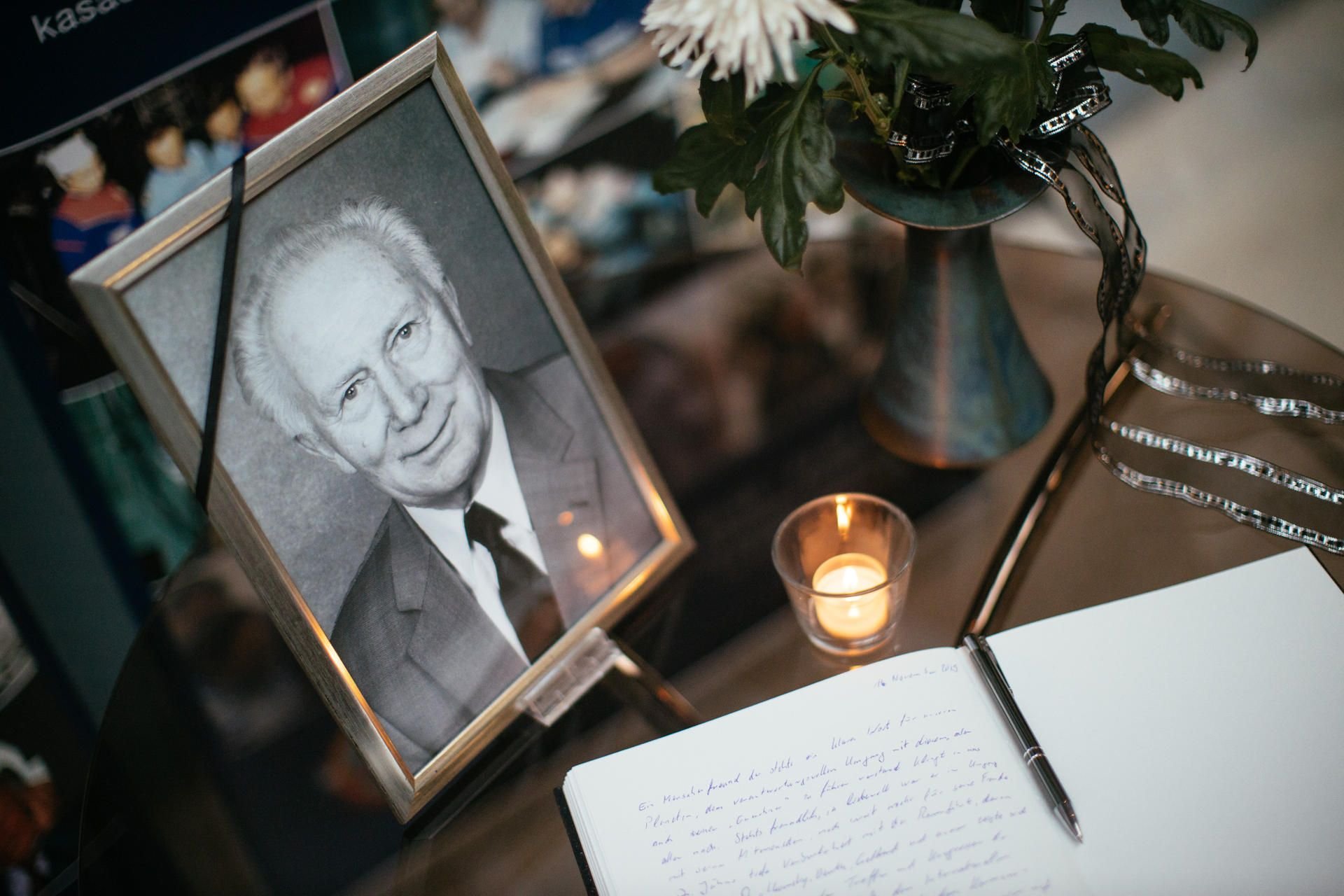 Ein Kondolenzbuch, eine Kerze, Blumen und ein Portrait stehen während einer Gedenkfeier für den DDR-Raumfahrer Sigmund Jähn im Deutschen Raumfahrtzentrum.