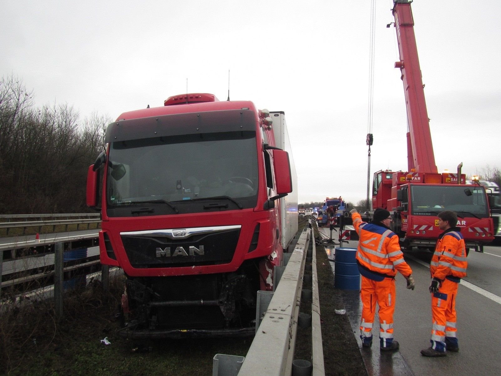 Ein beschädigter Lastwagen steht bei Alzey (Rheinland-Pfalz) auf der Autobahn 61 eingeklemmt zwischen zwei Leitplanken.