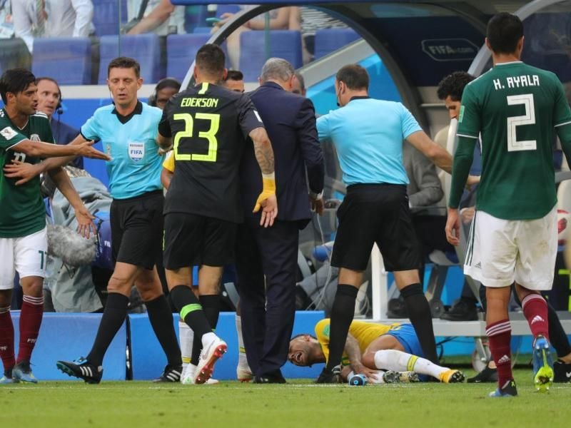 Neymar windet sich mit verzerrtem Gesicht am Boden, während Schiedsrichter Gianluca Rocchi (2.v.l.) versucht die Gemüter zu beruhigen. Foto: Christian Charisius