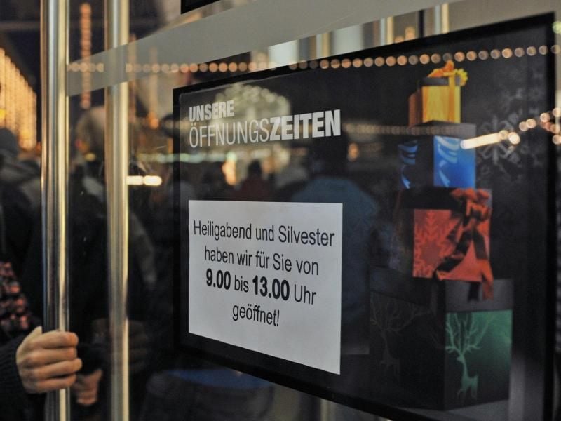 Ein Schild an einem Warenhaus informiert die Öffnungszeiten. Foto: Hendrik Schmidt/Archiv