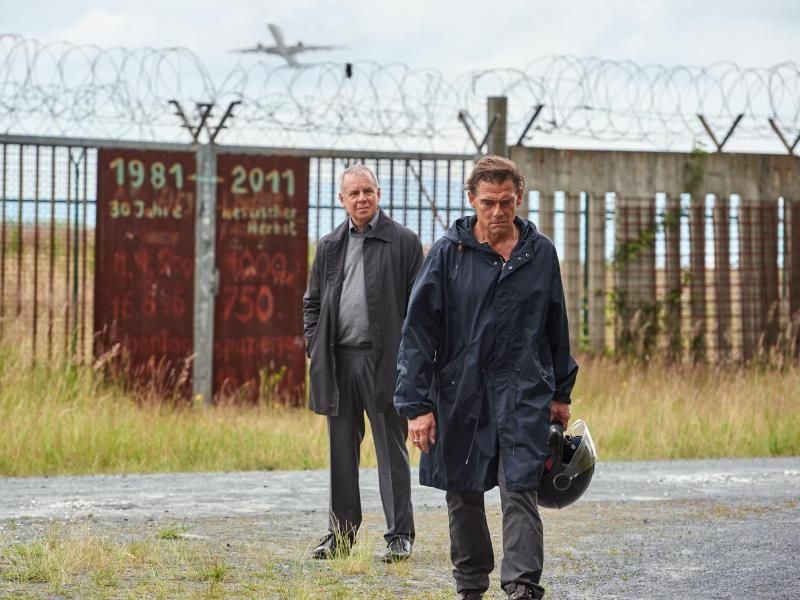 Wiedersehen an der Startbahn West mit einer überraschenden Erkenntnis: Herbert Wichert (Joachim Król, l) trifft Volker Jens (Martin Feifel). Foto: ZDF/Reiner Bajo