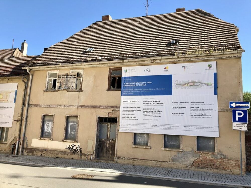 Vergangenheit und Zukunft liegen am Osterfelder Markt dicht beieinander. An der Ruine des Hauses Markt 3 informiert ein Plakat über das Bauprojekt am nahe liegenden Kirchberg.