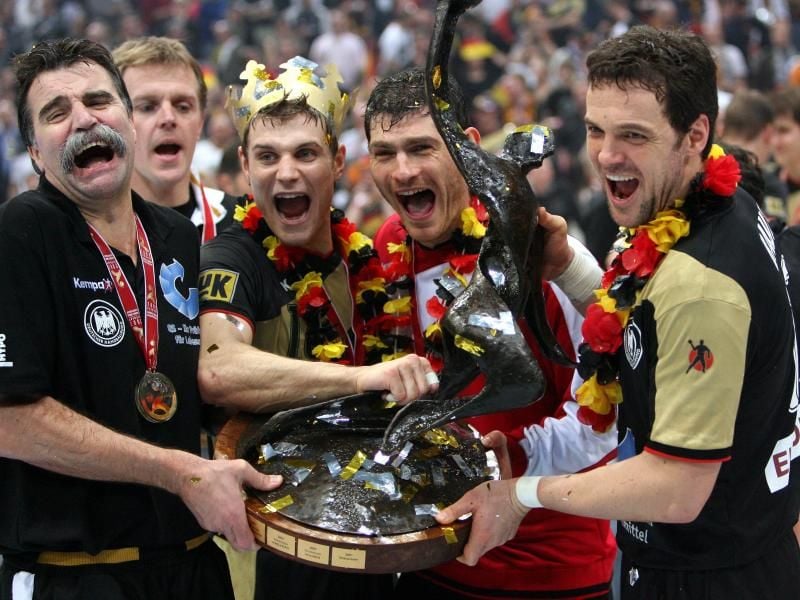 Handball-Weltmeister: Trainer Heiner Brand (l) hält am 4.2.2007 den WM-Pokal zusammen mit seinen Spielern Michael Kraus (mit Krone), Torwart Henning Fritz und Kapitän Markus Bauer (r). Foto: Franz-Peter Tschauner