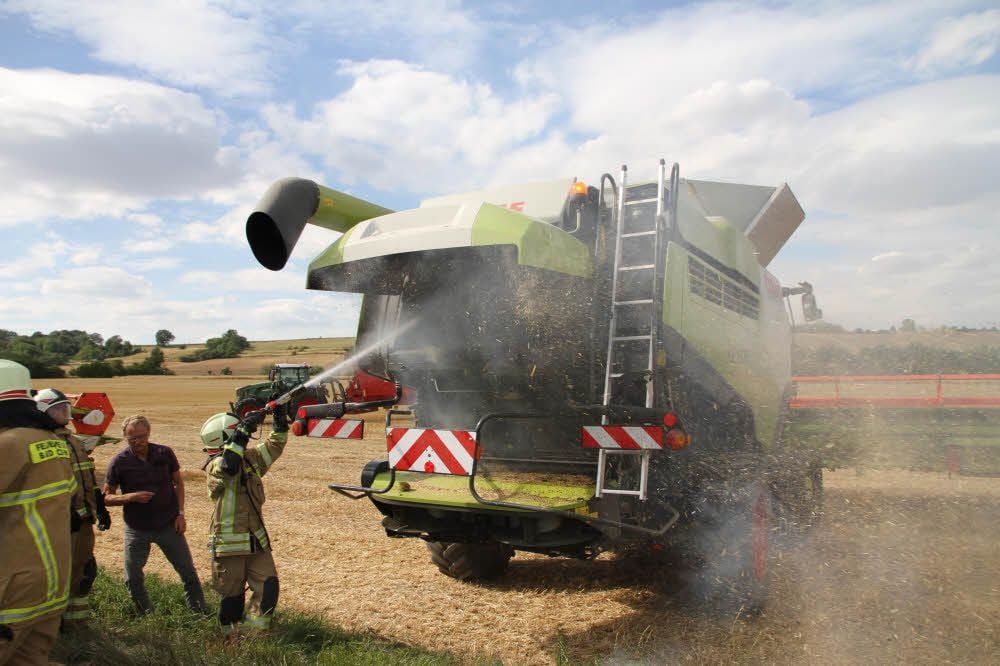 Die Feuerwehr Bad Kösen löscht den Brand in einem von zwei Mähdreschern auf einem Feld nahe dem Himmelreich.