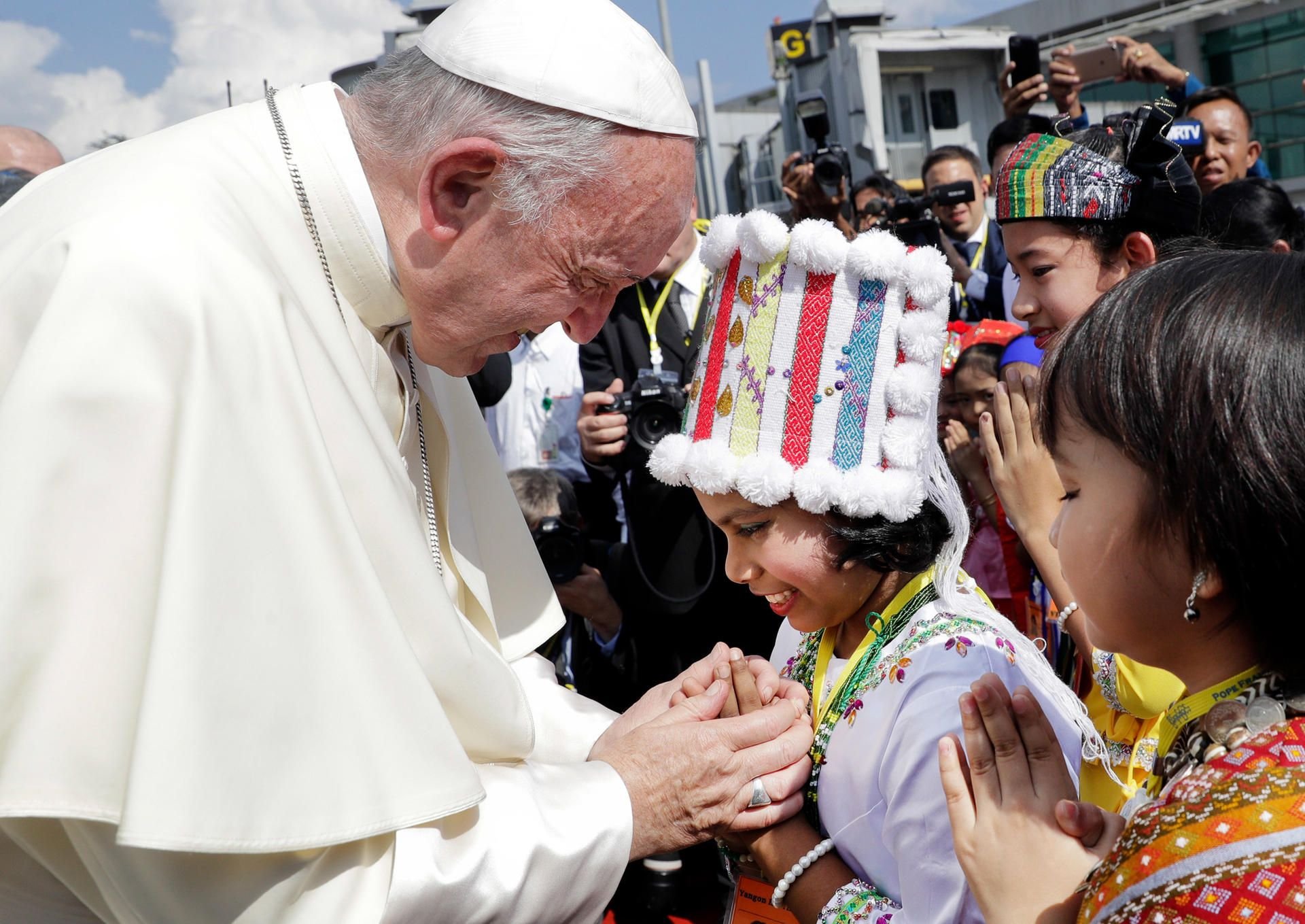 Papst Franziskus wird bei seiner Ankunft in Myanmar von Kindern in traditioneller Kleidung begrüßt.