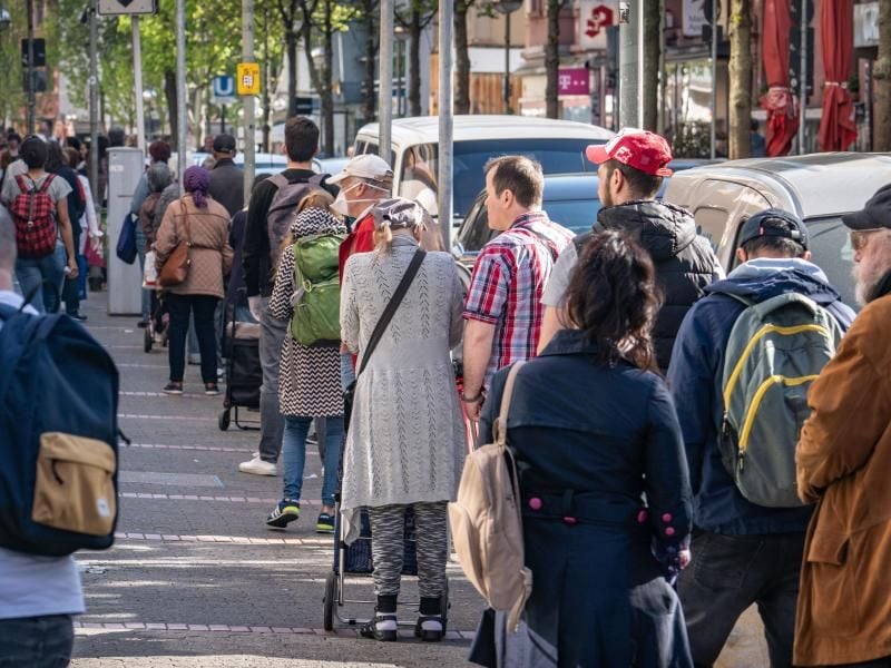 Mit Abstand warten Menschen in einer Schlange für einen Supermarkt. Foto: Frank Rumpenhorst/dpa