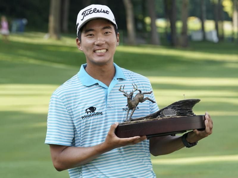 US-Golfer Michael Kim freut sich über seinen Sieg beim John Deere Classic in Silvis und posiert mit Trophäe. Foto: Charlie Neibergall/AP