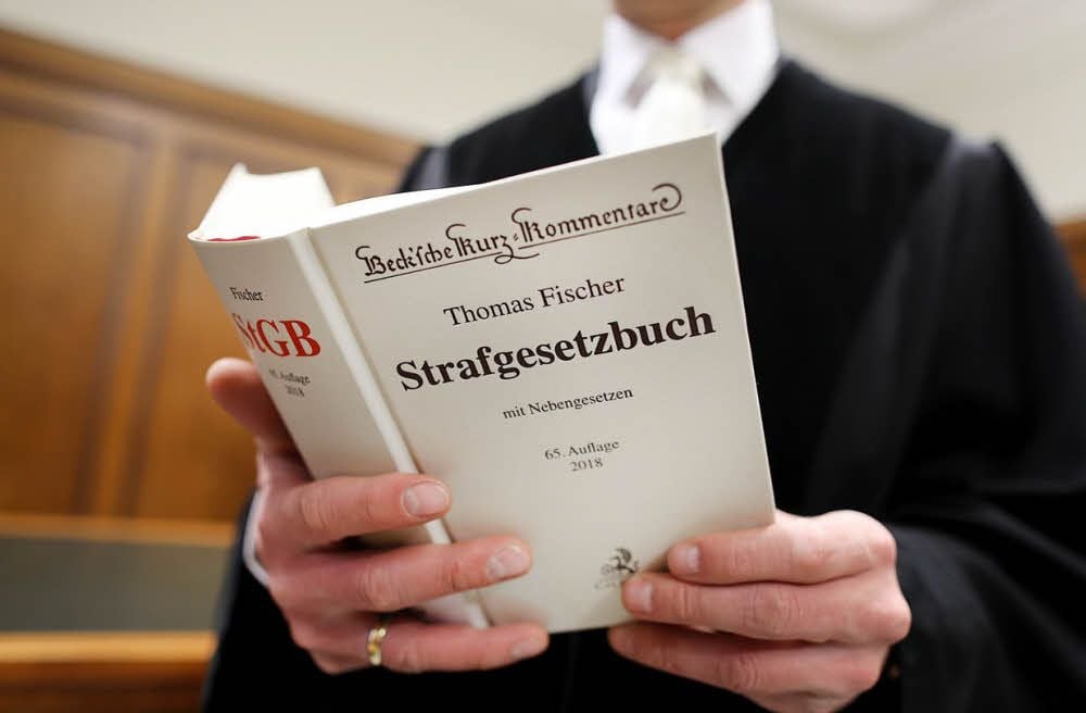 Ein Richter liest in Erläuterungen zum Strafgesetzbuch.