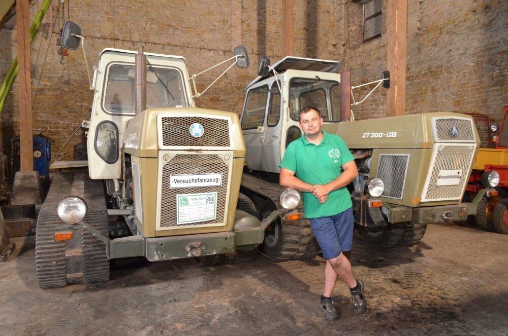 Nico Funke steht vor zwei Traktoren vom Typ ZT, von denen es nur noch wenige fahrbereite Modelle gibt.
