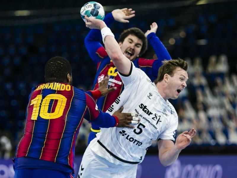 Kiels Sander Sagosen (r) kann sich am Wurfkreis gegen zwei Spieler des FC Barcelona durchsetzen. Foto: Frank Molter/dpa