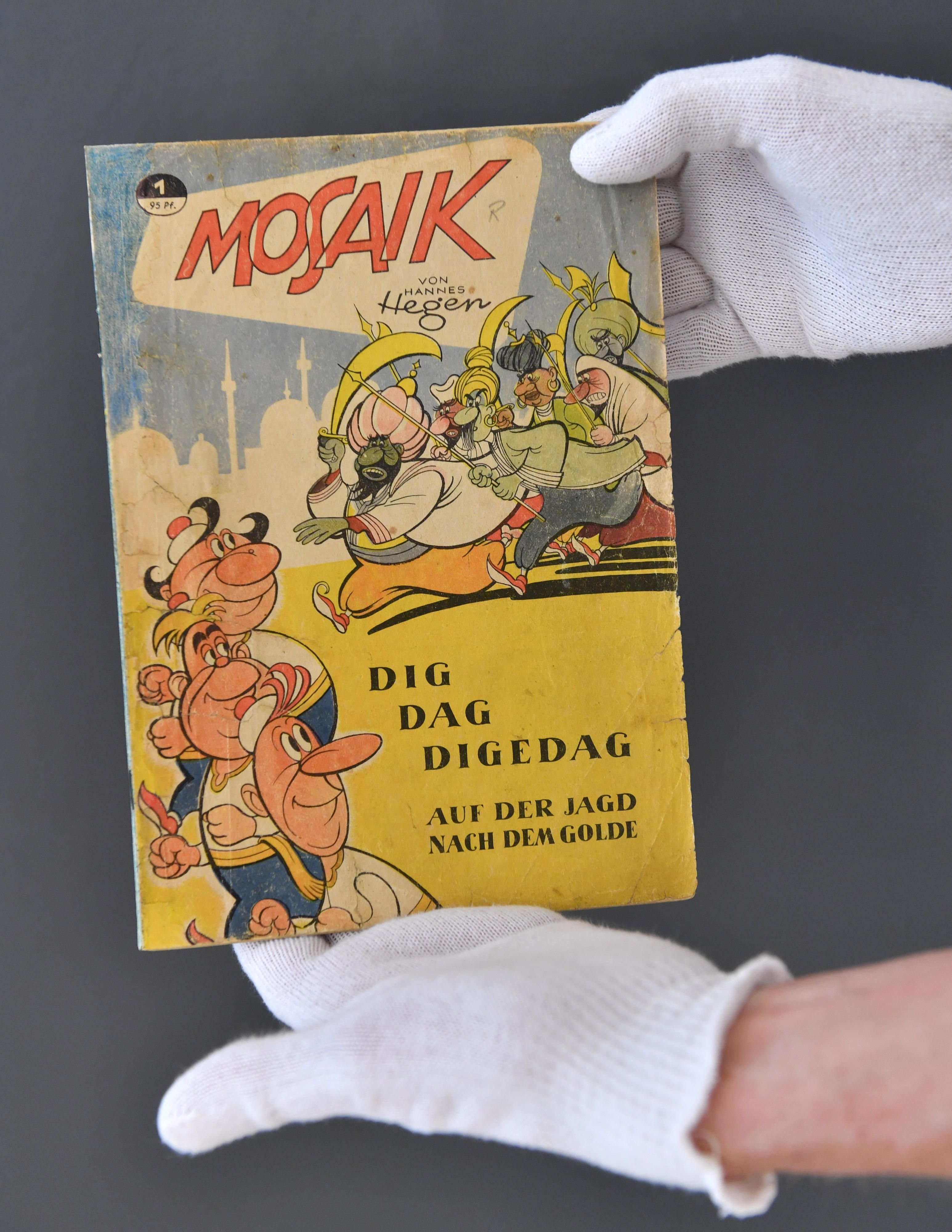 Vor Beginn der Ausstellung "Comic in der DDR" präsentiert der Kurator im Stadtmuseum in Gera (Thüringen) ein Original des ersten Mosaik-Heftes vom Dezember 1955