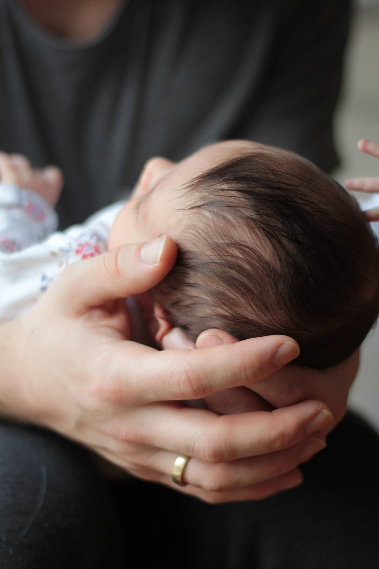 Eine Mutter hält ihr Baby in den Händen.