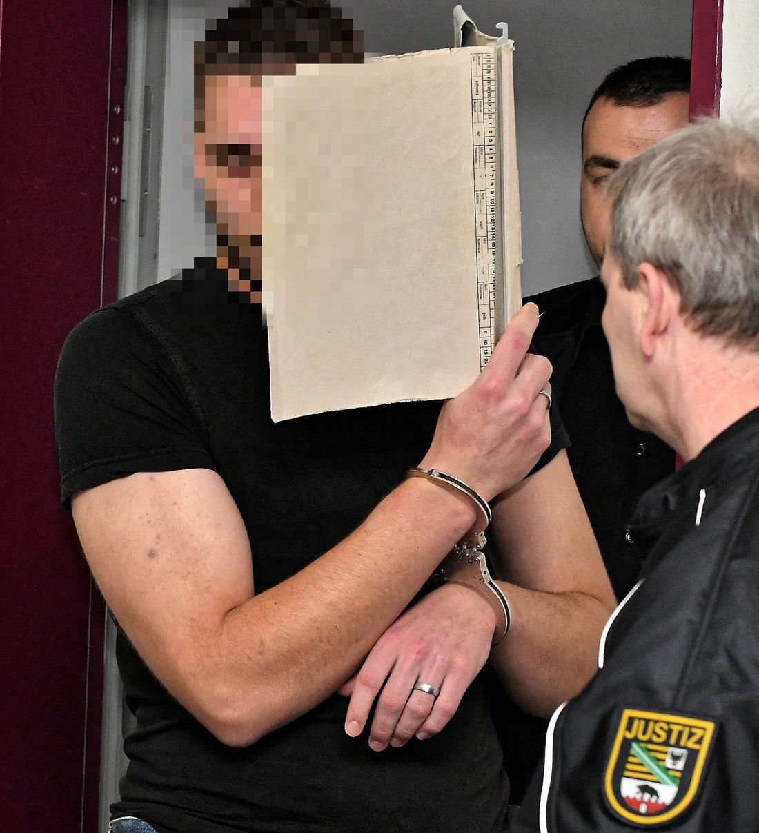 Justizbeamte führen Sebastian F. zur Verhandlung in den Gerichtssaal in Dessau.