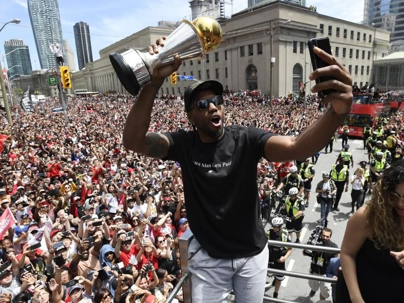 Kawhi Leonard (M) feiert mit zehntausenden Fans den NBA-Titel mit den Toronto Raptors. Foto:b Frank Gunn/The Canadian Press