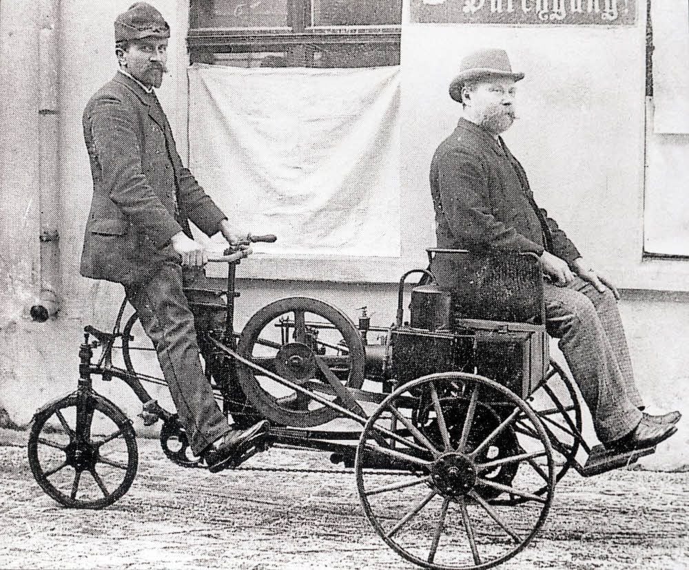 Friedrich Lutzmann (l.) 1895 am Steuer seines Motordreirades, rechts ist sein Freund Fritz Koch zu sehen.