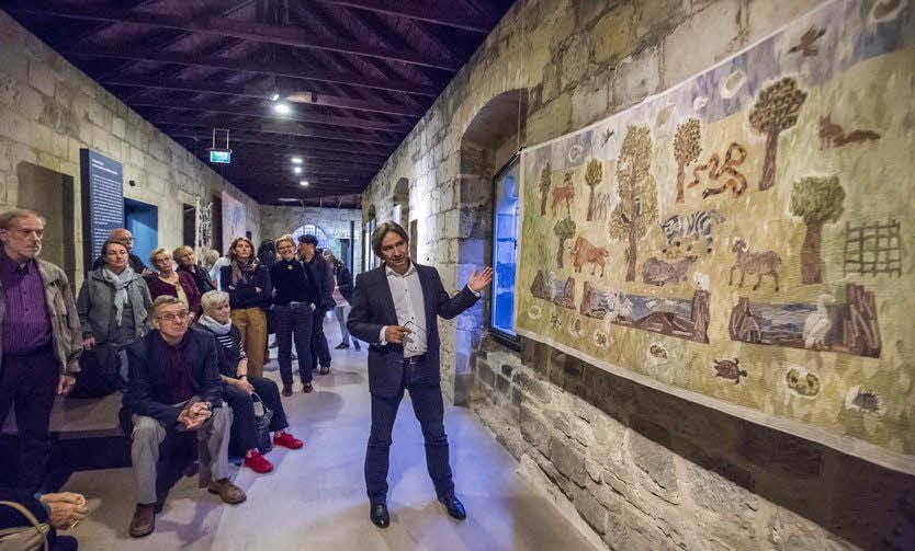 Kurator Björn Raupach führt Besucher durch die Bildteppich-Ausstellung im Halberstädter Domschatz.