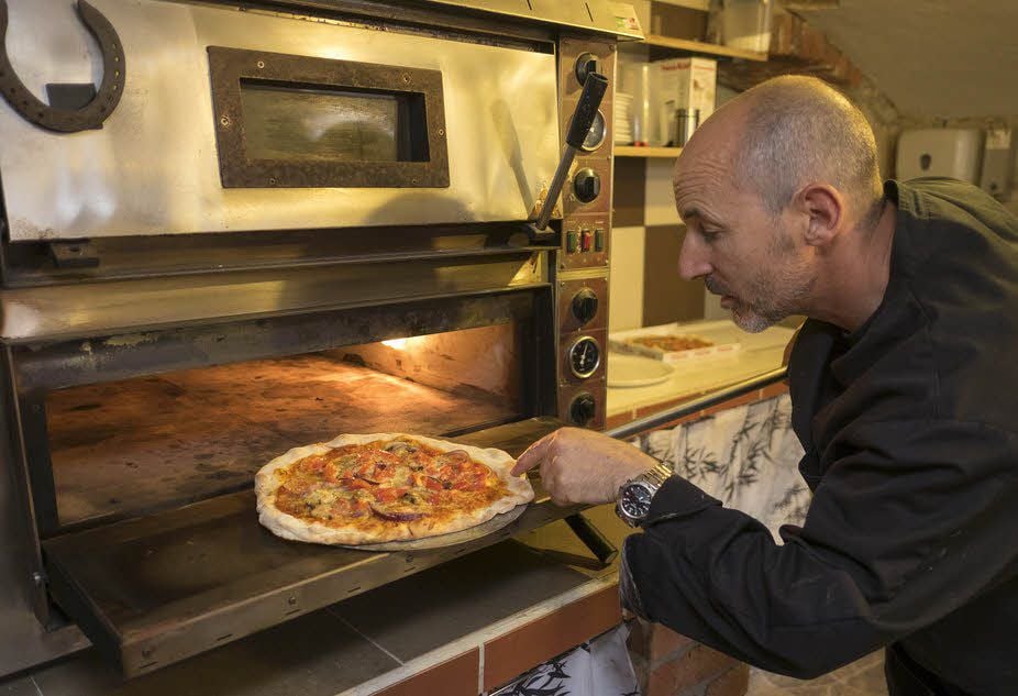 Wenn Massimo Caraccioli die Pizza aus dem Ofen holt, muss der Teig auf den Punkt durch sein.