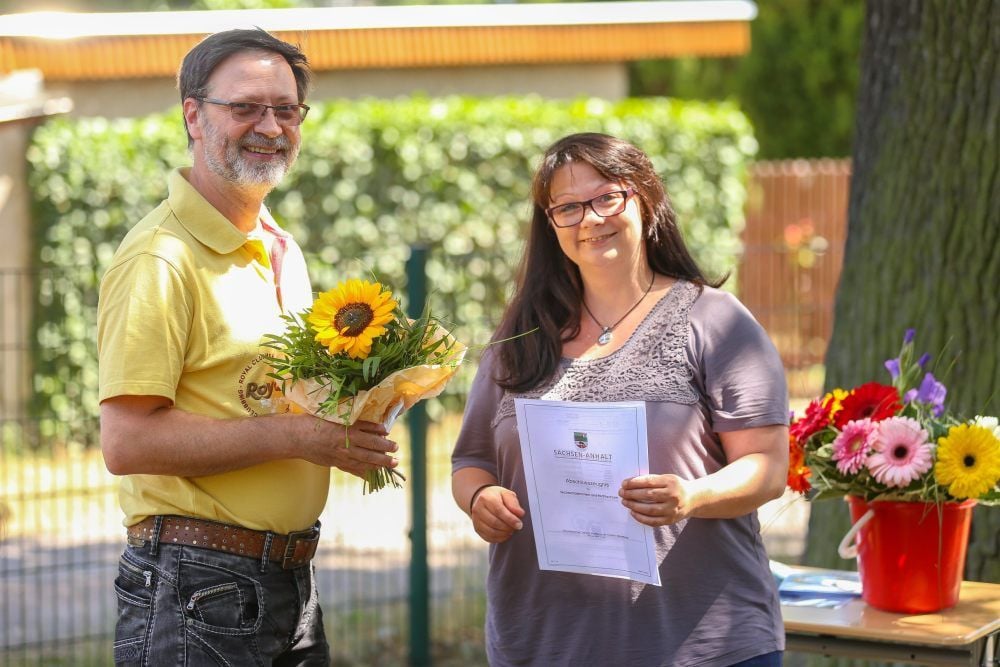 Dana Fröhlich (rechts) erhält von Gunnar Hensel von der Kreisvolkshochschule Saalekreis (links) ihren Realschulabschluss.