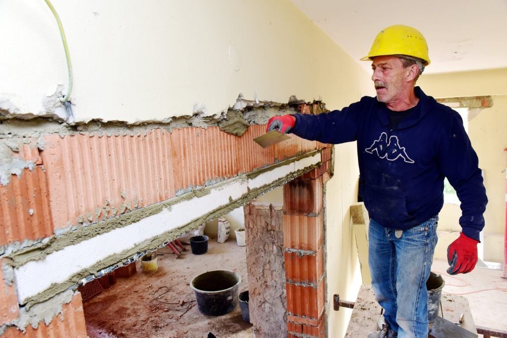 Michael Nötzel verspachtelt eine Wand im alten Krankenhaus.