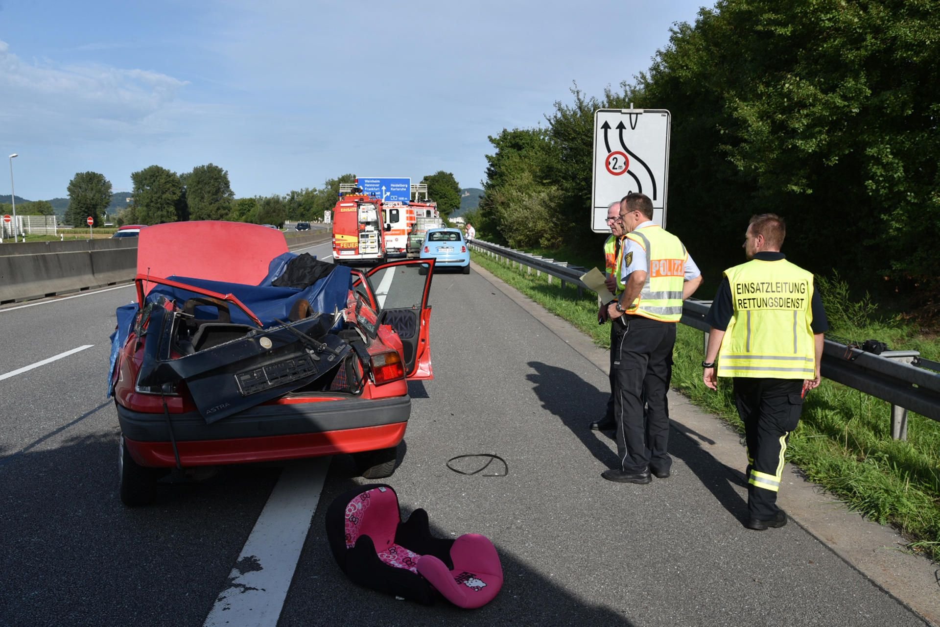 Polizisten und Rettungskräfte neben dem zertrümmerten Auto. Ein 18-Jähriger ist nahe Mannheim von einer Baggerschaufel erschlagen worden.
