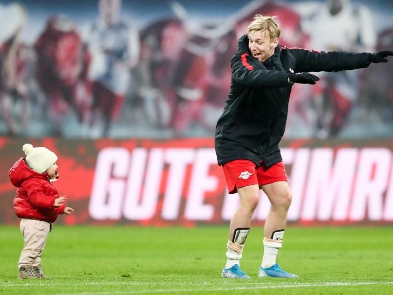 Emil Forsberg unterhält Tochter Florence auf dem Spielfeld. Foto: Jan Woitas/dpa-Zentralbild/dpa