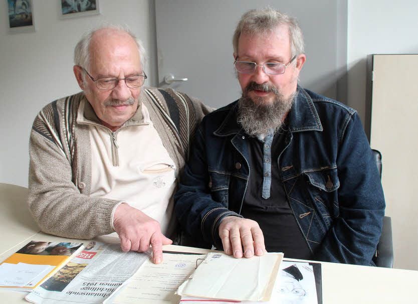Wilfried und Burkhard Büttner blättern beim Besuch in der Redaktion in ihren Unterlagen.