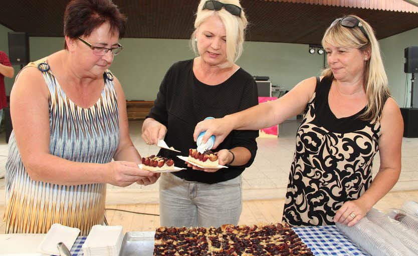 Bei der Eröffnung des 241. Pflaumenkuchenmarktes verteilen die Gemeinderatsmitglieder den traditionellen Pflaumenkuchen.