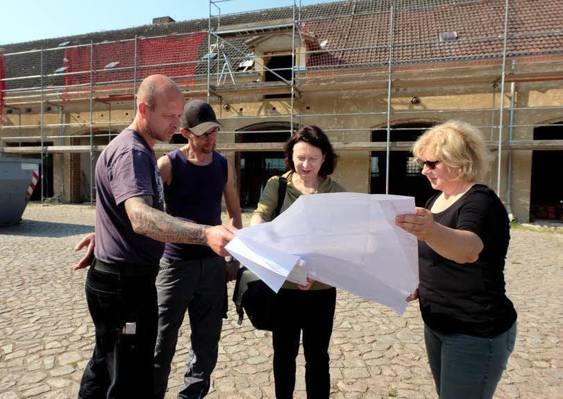 Christian Holz, Thomas Hanke, Architektin Mara Pinardi und Ines Köhler (von links) schauen sich gemeinsam die Baupläne an.