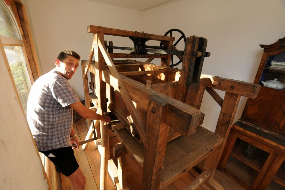Bad Kösens Ortsbürgermeister Holger Fritzsche präsentiert die noch sehr gut funktionierende, wohl 150 Jahre alte hölzerne Wäschemangel.