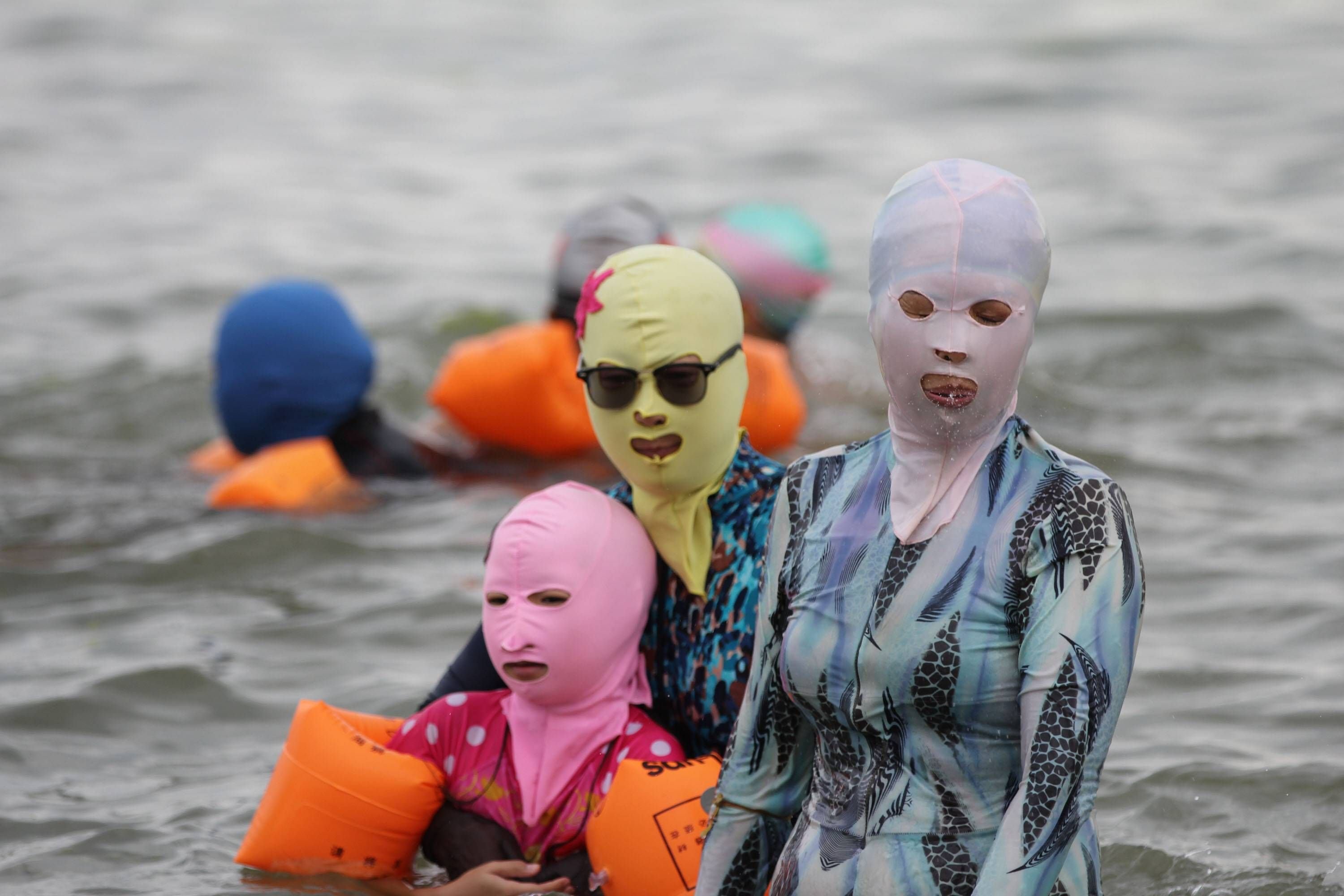 Mit Sonnenbrille, Schwimmflügeln und Facekini: So gehen diese Damen am Strand von Qingdao baden.