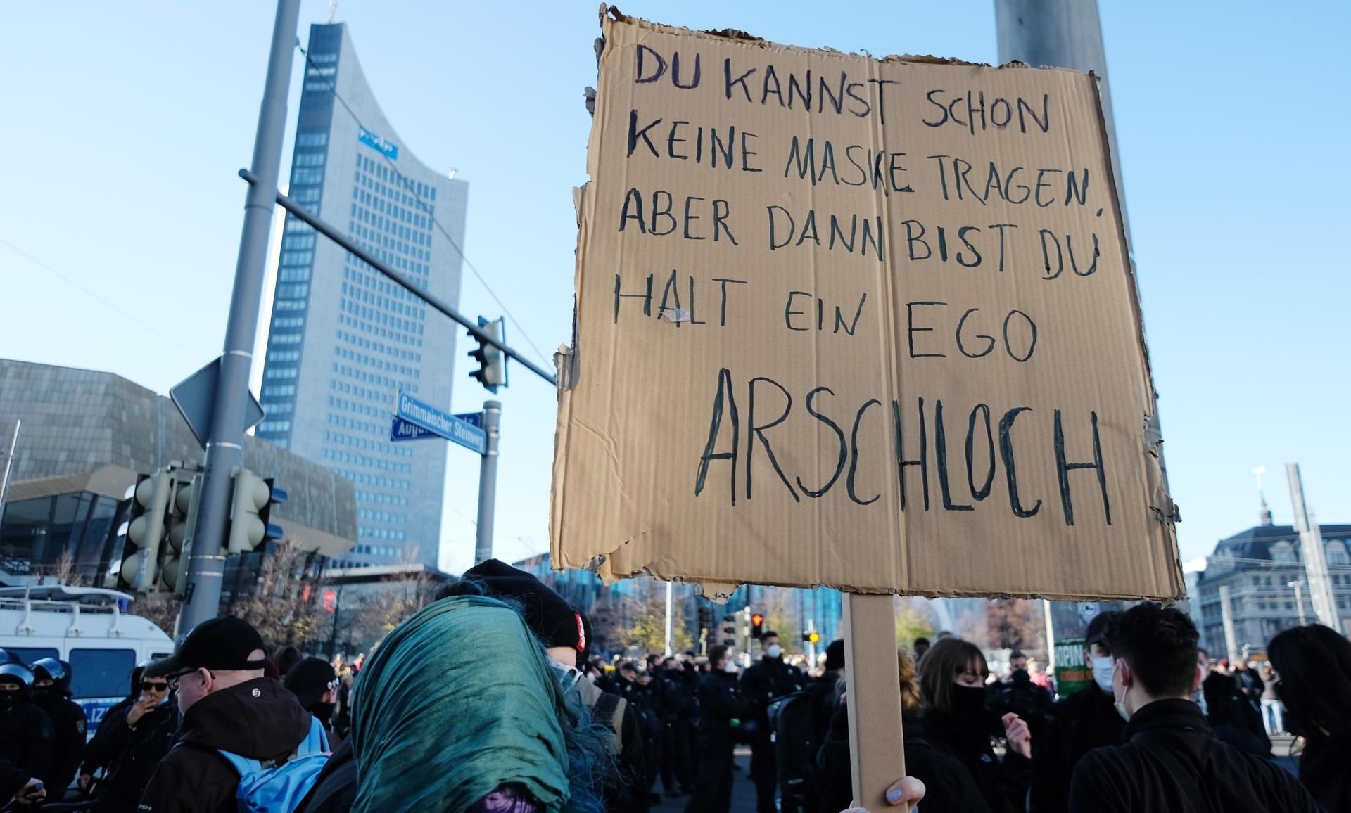 Eine Teilnehmerin einer Demonstration gegen die Kundgebung der Initiative ·Querdenken· hält auf dem Augustusplatz ein Papp-Schild hoch.