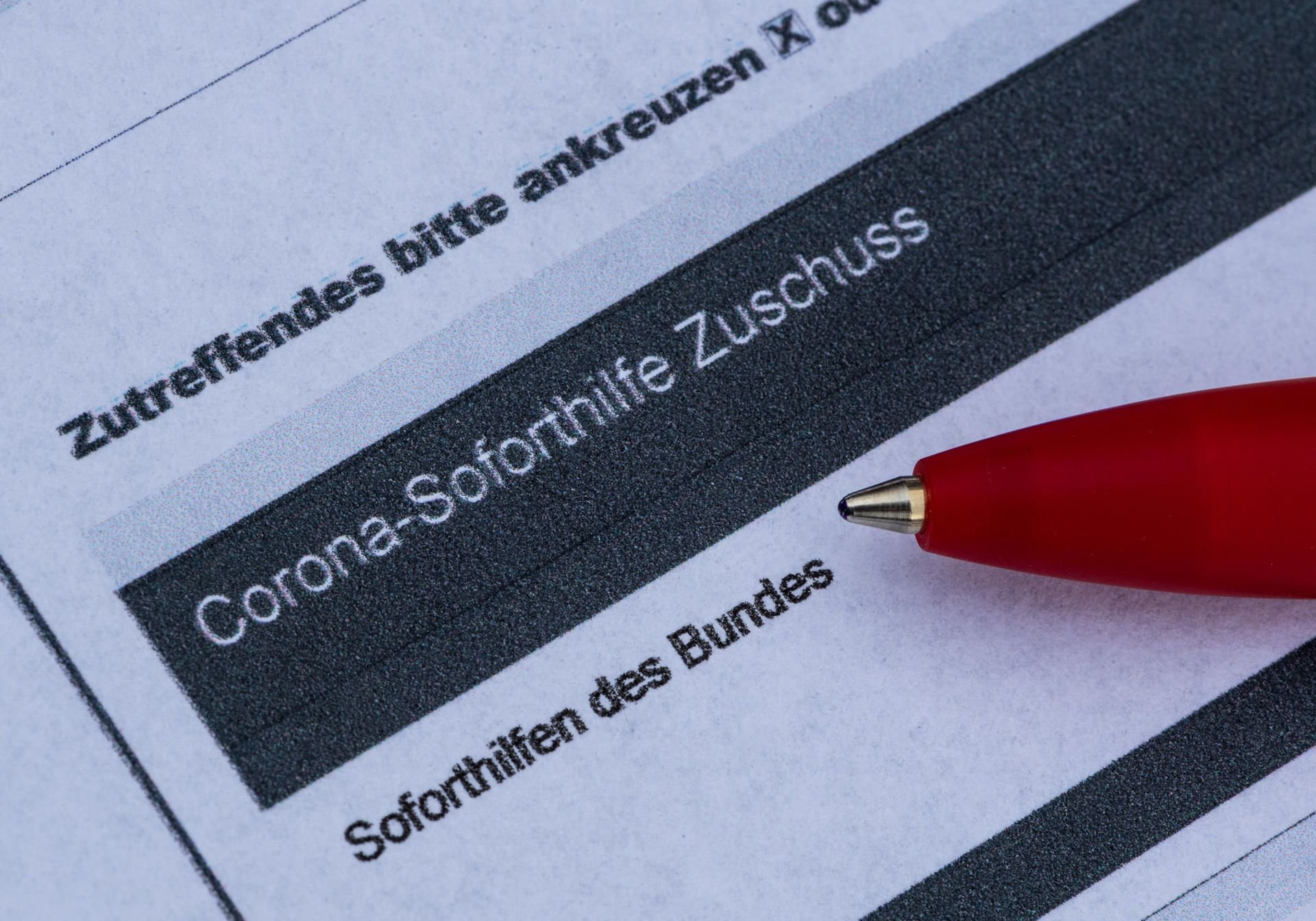 Ein Stift liegt auf einem Antrag auf Corona-Soforthilfe Zuschuss
