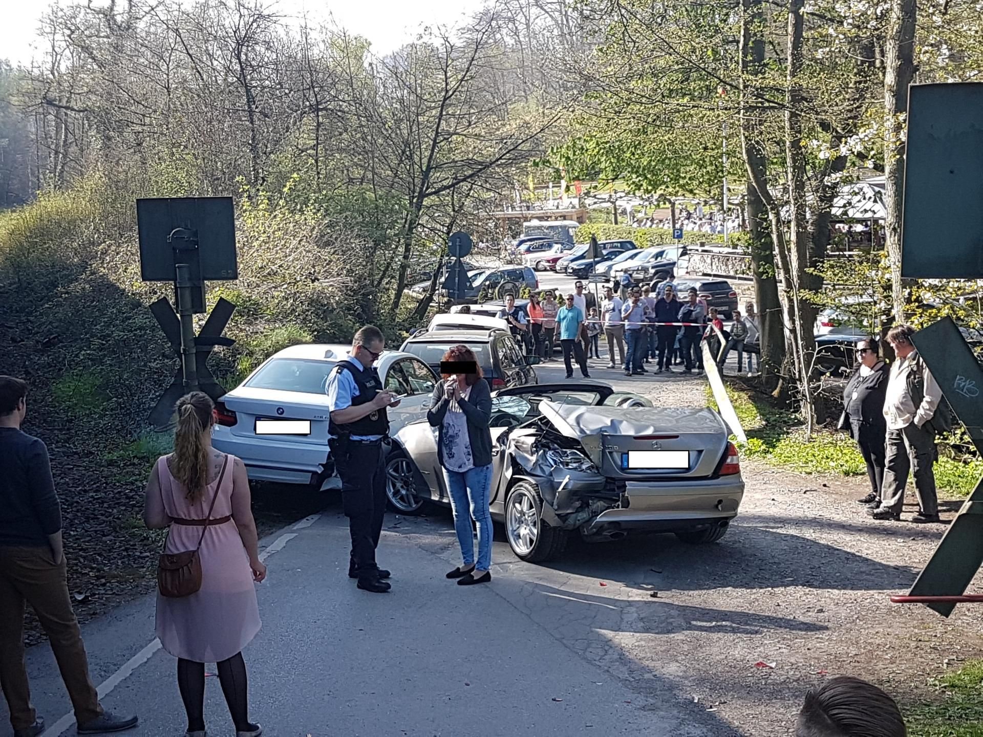 Spaziergänger beobachten, wie ein Polizist in Ratingen (Nordrhein-Westfalen) einen Unfall aufnimmt. Weil er keinen freien Parkplatz mehr fand, hat ein Mann seinen Wagen auf einem unbeschrankten Bahnübergang abgestellt.