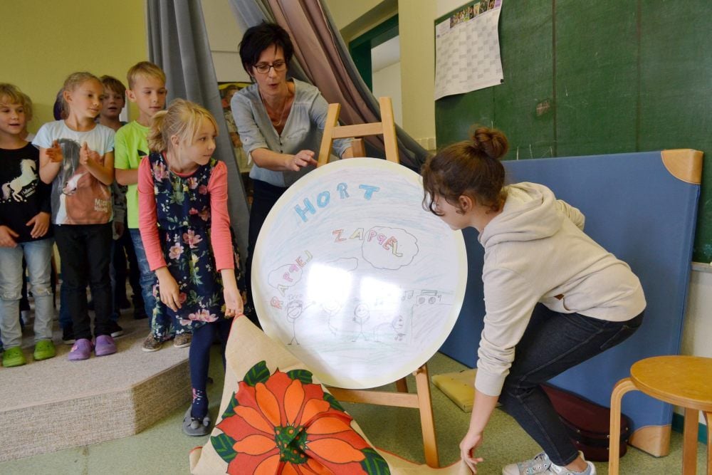 Feierlich enthüllten die Kinder des Hortes in Prettin am Dienstagnachmittag die Tafel mit dem neuen Namen „Rappel Zappel“.