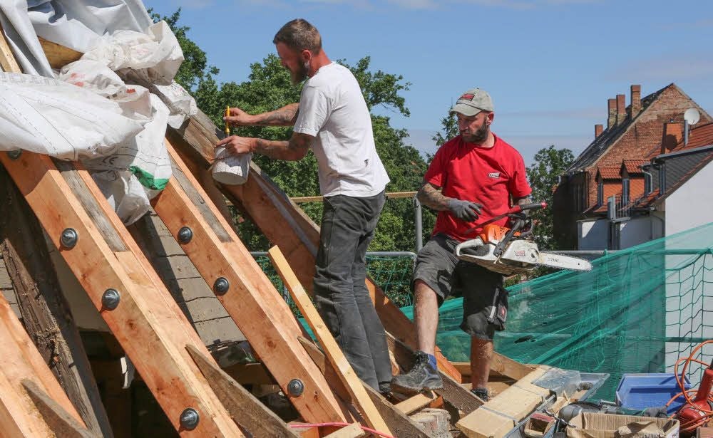 Jörg Spiegelberg und Karsten Bocher von der Firma Wolter arbeiten am Dach, das undicht war. Drei Wohnungen entstehen hier.