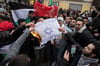 Bei einer Demonstration in Berlin verbrennen Menschen eine Flagge mit einem Davidstern.