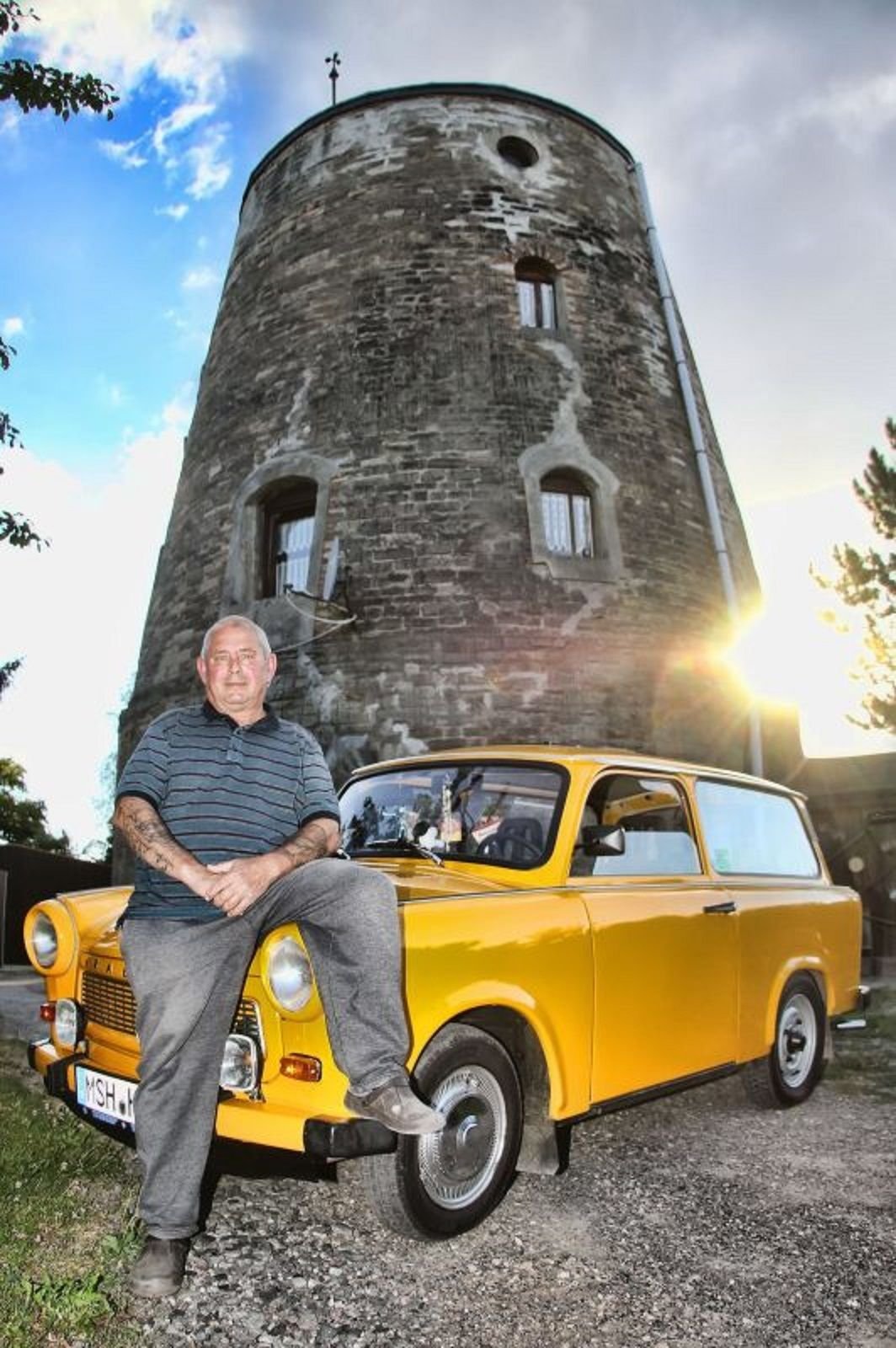 Hartmut Otto mit seinem melonengelben Trabi vor der Hettstedter Windmühle